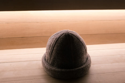 Back view of a charcoal gray Schvitzin wool felt sauna hat, showing the structured seam detail and black leather adjustable buckle strap
